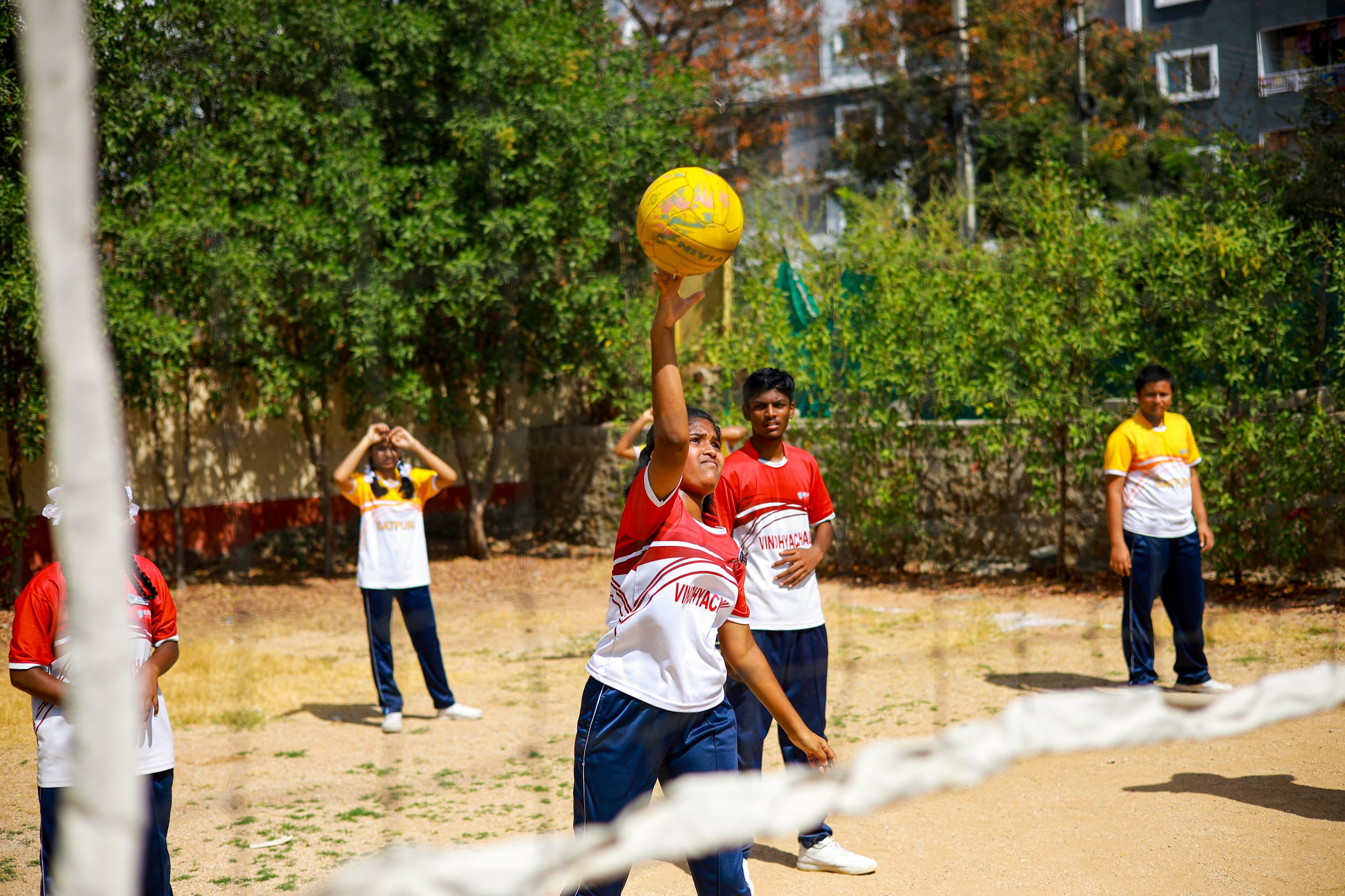 Enthusiastic students participating in a spirited game of throwball at Kiran International School, showcasing teamwork and sportsmanship in an energetic and competitive setting.