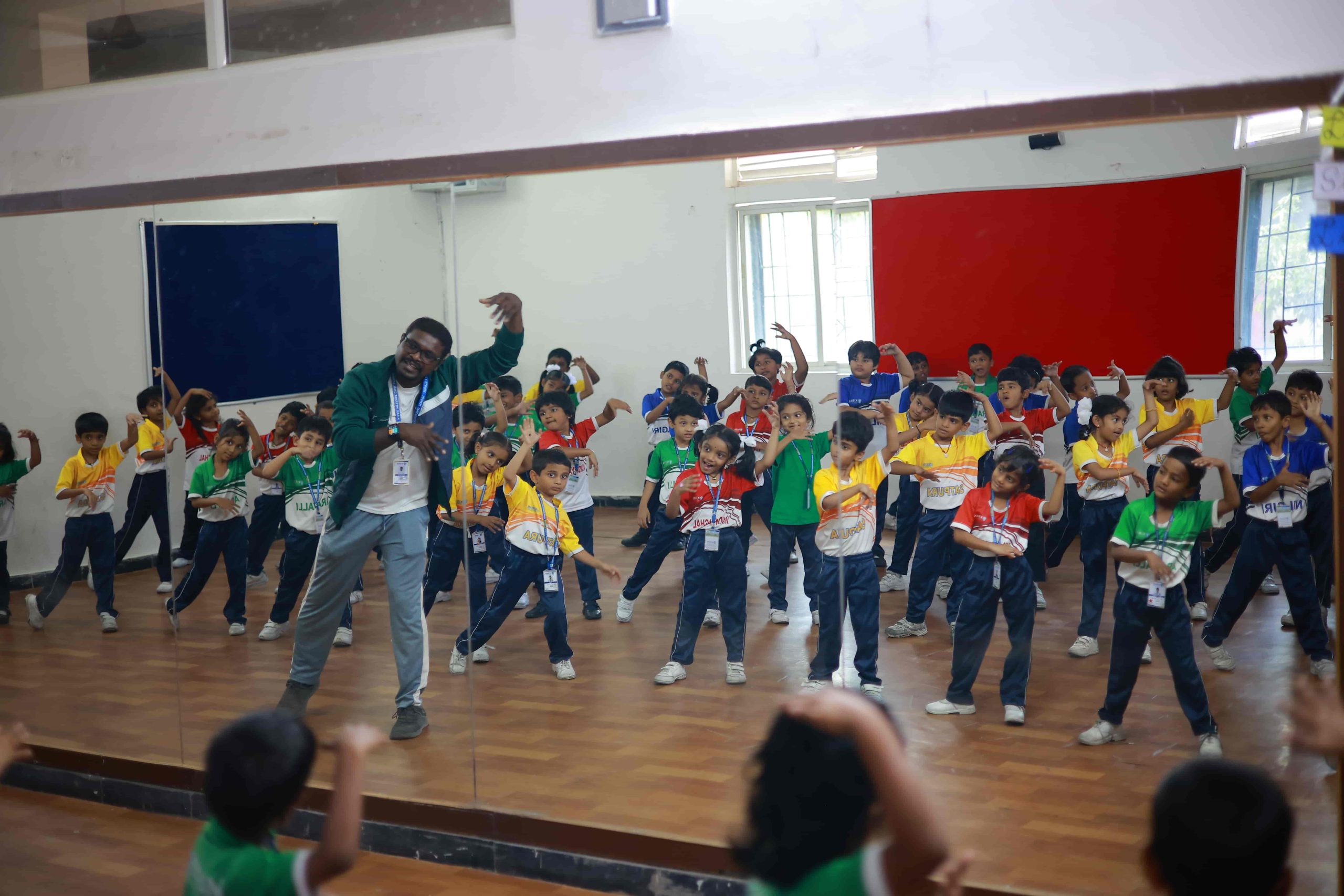 Energetic students dancing in the dance room at Kiran International School, featuring a one-sided mirror facility for enhanced learning and self-reflection during dance sessions.