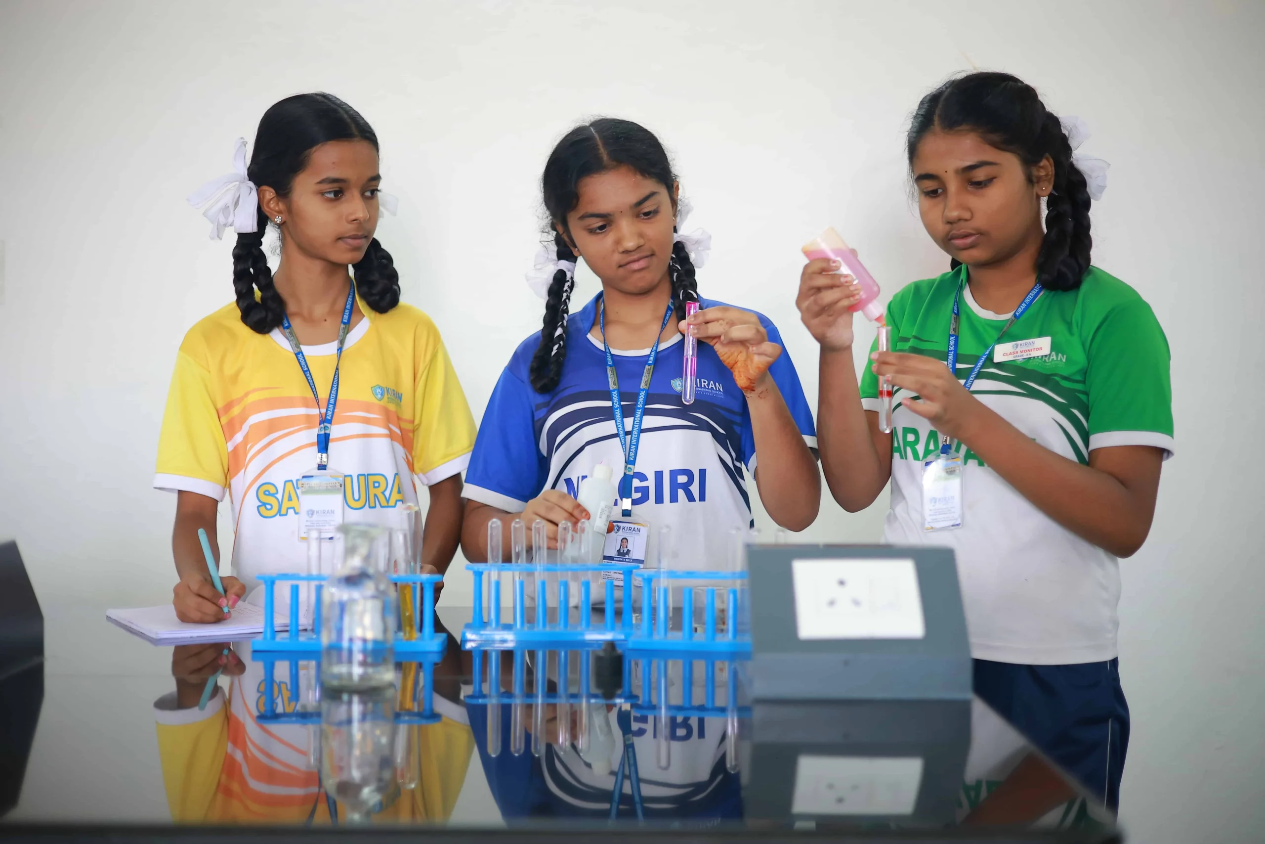 Students engaged in a hands-on science practical, conducting experiments with laboratory equipment, fostering a dynamic and experiential learning environment.